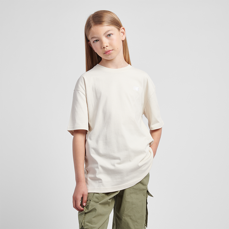 

Dětské tričko New Balance LAKG0001LIN – béžové
